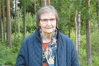 Peterin puolipotretti, jossa hän seisoo metsässä. 