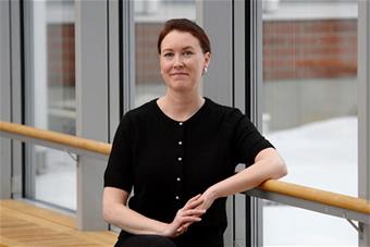 Puolipotretti Yhjänheikistä lasisen seinän edessä.