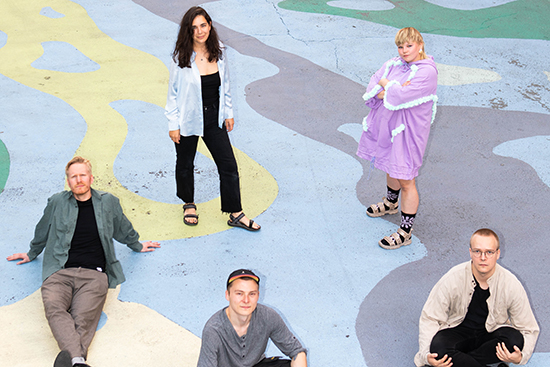 Elokuvan nuoret tekijät ryhmäkuvassa värikkääksi maalattua taustaa vasten.