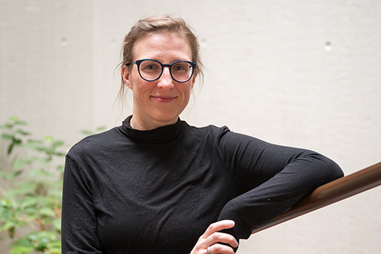 Sopraano Hanna Rantala nojaa porraskaiteeseen, taustallaan viherkasveja. Valokuva: Tapio Nykänen.