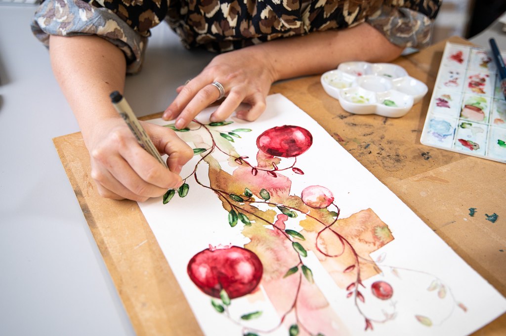 "Nainen kuvittaa kukkia isolle kanvaasille."