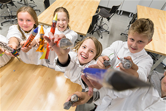 Lapset iloisena rakettikerhossa.