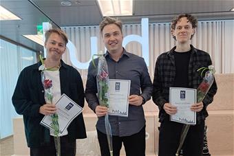 Huld Design Award 2023 -kilpailun voittajat Heikki-Veikko Lämsä, Emil Aukusti Mäenpää ja Markus Salmi, käsissään palkintoruusut ja -todistukset. Kuva: Huld Oy.