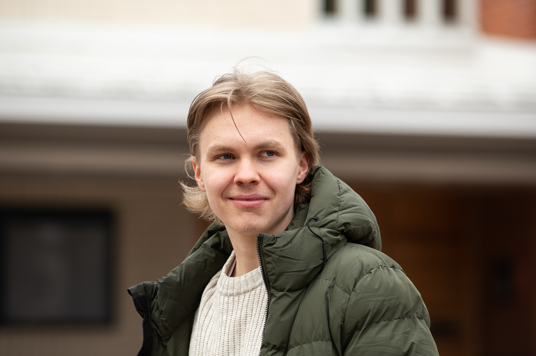 "Nuori mies toppatakissa katsoo kameraan Lapin yliopiston pihalla."