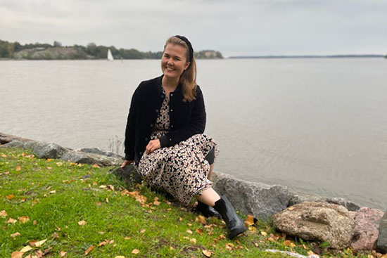 Kuvassa Salla Karima istumassa merenrannalla. 