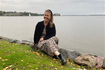 Kuvassa Salla Karima istumassa merenrannalla. 