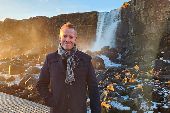 Mikko Kiiski seisoo kallioisen vesiputouksen äärellä.