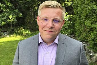 Juho Mäki-Lohiluoma taustallaan kesäistä puustoa.