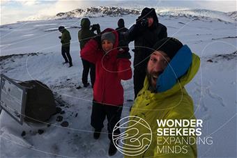 Valokuvia ottavia matkailijoita lumisessa maisemassa.