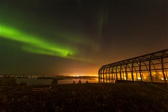 Vihreät revontulet taivaalla Arktikum-talon yläpuolella.