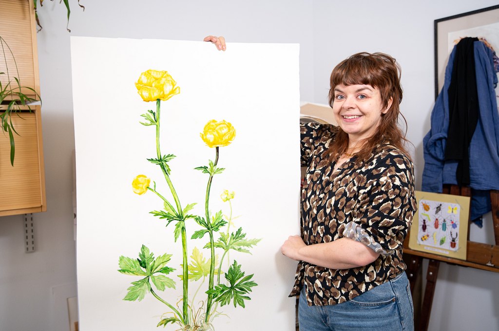 Nainen jättimäisen kullervomaalauksen vieressä.