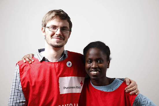 Kaksi henkilöä Punaisen Ristin vapaaehtoisen asussa. Kuva: Enni Kasvi.