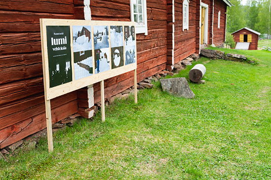 Museoesineitä lumiveistoksina -näyttelyn vaokuvat nojaamassa Rovaniemen kotiseutumuseon hirsiseinään. Kuva: Inka Holck.