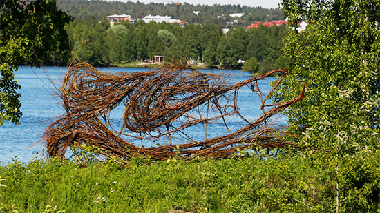Pajusta tehty veistos, jossa lohen siluetti Kemijoen rannalla. Kuva: Maria Huhmarniemi.