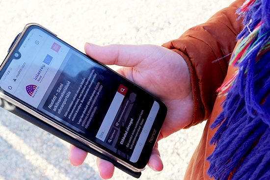 Ihmisen kädessä puhelin, jossa on avoinna Nuohtti-palvelun etusivu. Kuva: Matilda Kalving.