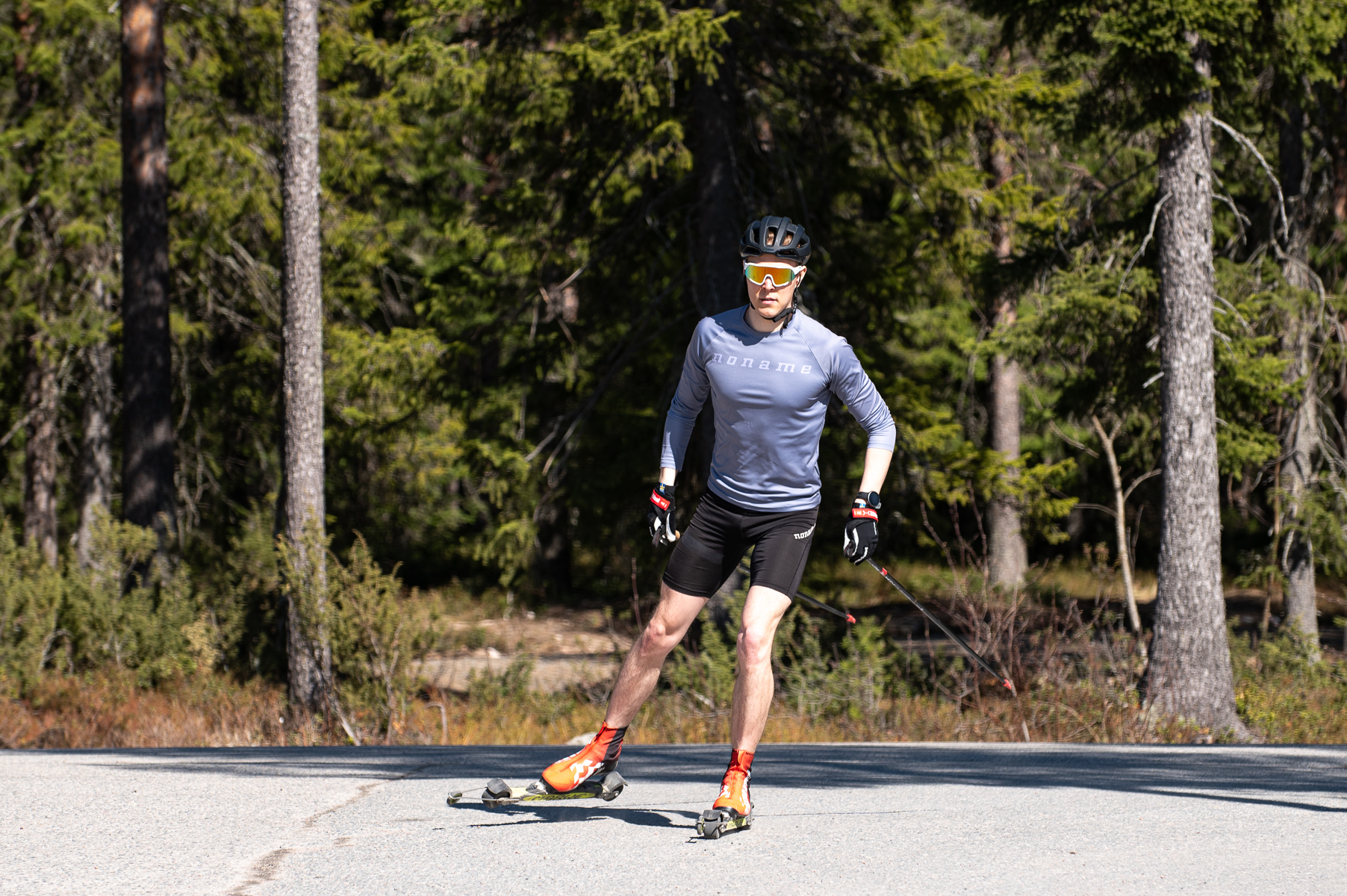 Mies rullaluistelee sauvojen kanssa metsämaisemaa vasten.