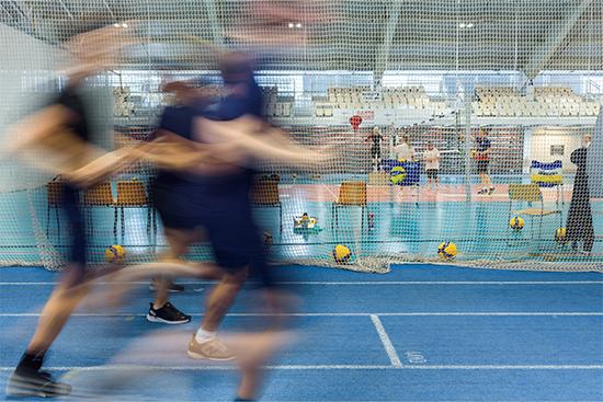 Juoksevia ja lentopalloa pelaavia ihmisiä