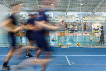 Juoksevia ja lentopalloa pelaavia ihmisiä