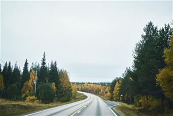 Maantien kuva ruskaisen maiseman keskellä. 