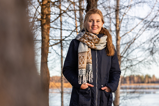 Karolina Sikora by the riverbank of Ounasjoki on a bright autumn day.