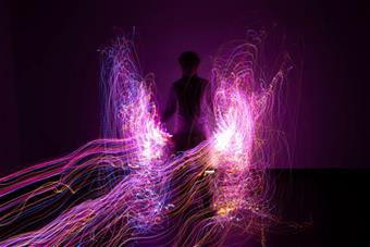 Tumman hahmon edessä valoviiruja