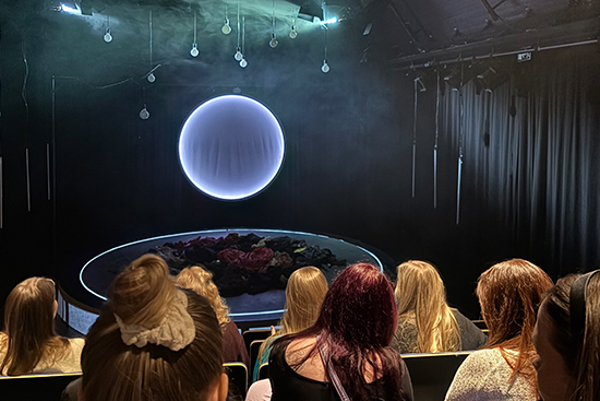 Opiskelijoita teatterisalissa katsomassa näytelmää