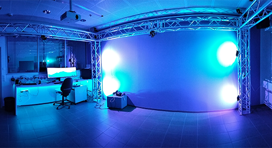 XR-laboratorion tila, jossa iso seinäpaneeli valotehostein, valaistustelineitä ja keskusyksikkö.