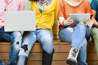 Opiskelijat digilaitteiden kanssa.