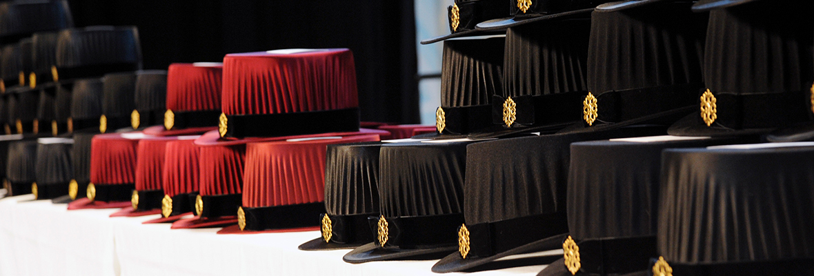 Mustia ja viininpunaisia tohtorinhattuja rivissä. Kuva: Jouni Porsanger.