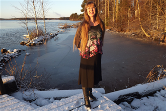 Kuvassa Anna Kekki seisoo lumisella rannalla järvimaisemassa.