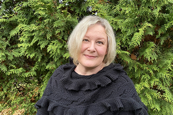 Kuvassa puolipotretti Pietarilasta, taustalla vehmas pensas. 