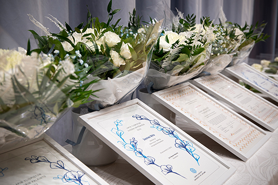 Kunniakirjoja ja kukkakimppuja. Kuva: Elli Alasaari.