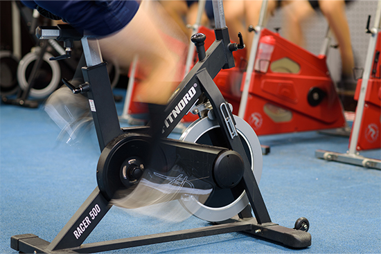 Kuntopyörällä polkevia ihmisiä