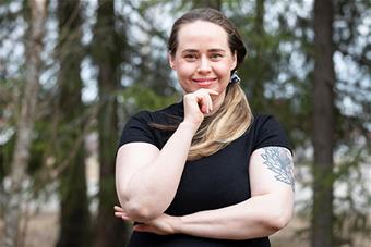 Jenna Päläs, taustalla havupuita.