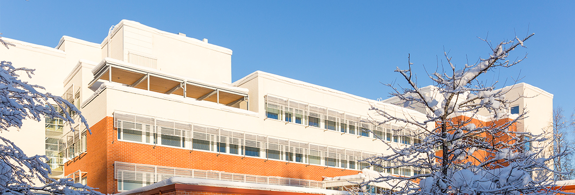 Lapin yliopiston taiteiden tiedekunnan rakennus ulkoa kevättalvella auringon paisteessa.